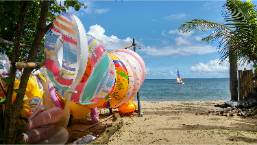 Beach access with colorful inflatable water toys near the shore