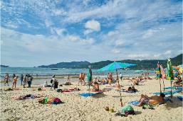Hotel beach area with umbrellas and people relaxing by the water
