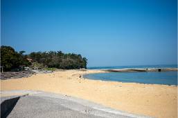 Sandy beach area with clear sky near hotel or resort