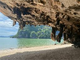 View of beach and sea from a rocky cave at hotel area