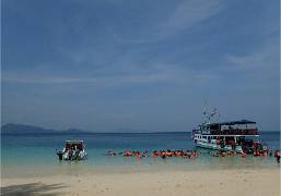 Beach area with boats and swimmers at a hotel seaside location