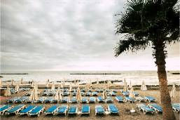 Rows of beach loungers and umbrellas on a resort beach