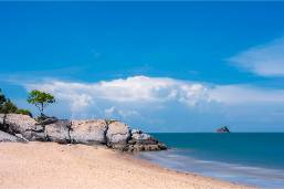 Beach area with sand, rocks, and ocean view beside the hotel