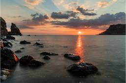 Sunset view over rocky coastline near hotel beach area