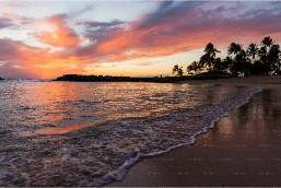 Beach view with gentle waves and sunset near hotel property