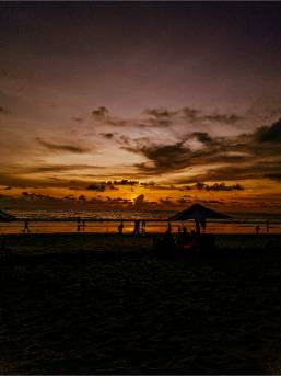 Sunset view over the hotel beach with silhouetted umbrellas