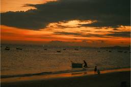 Beach view at sunset with boats along the shoreline