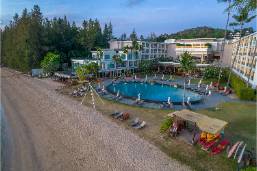 Outdoor pool area next to hotel buildings and beach