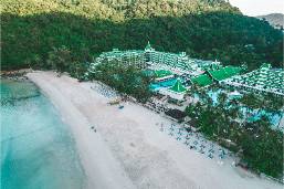Resort hotel located along a beach with green forested hills