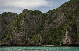 Rocky cliffs covered with greenery next to the sea at hotel area