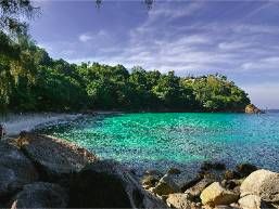 Secluded beach area with clear blue water and rocky shore