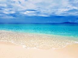 Sandy beach with clear blue water and distant islands