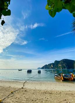 Beach shoreline with boats and clear sky at a resort location