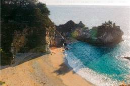 Sandy beach area with cliffs and ocean water at a coastal resort