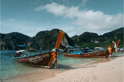 Two boats anchored on a beach near hotel or resort coastline