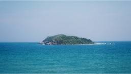 View of an island surrounded by clear blue ocean water