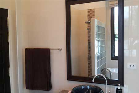 Thai Life / North Khao Lak location or resort-context image showing modern bathroom sink mirror and towel. This supports understanding the surrounding lifestyle and is not represented as the house itself.