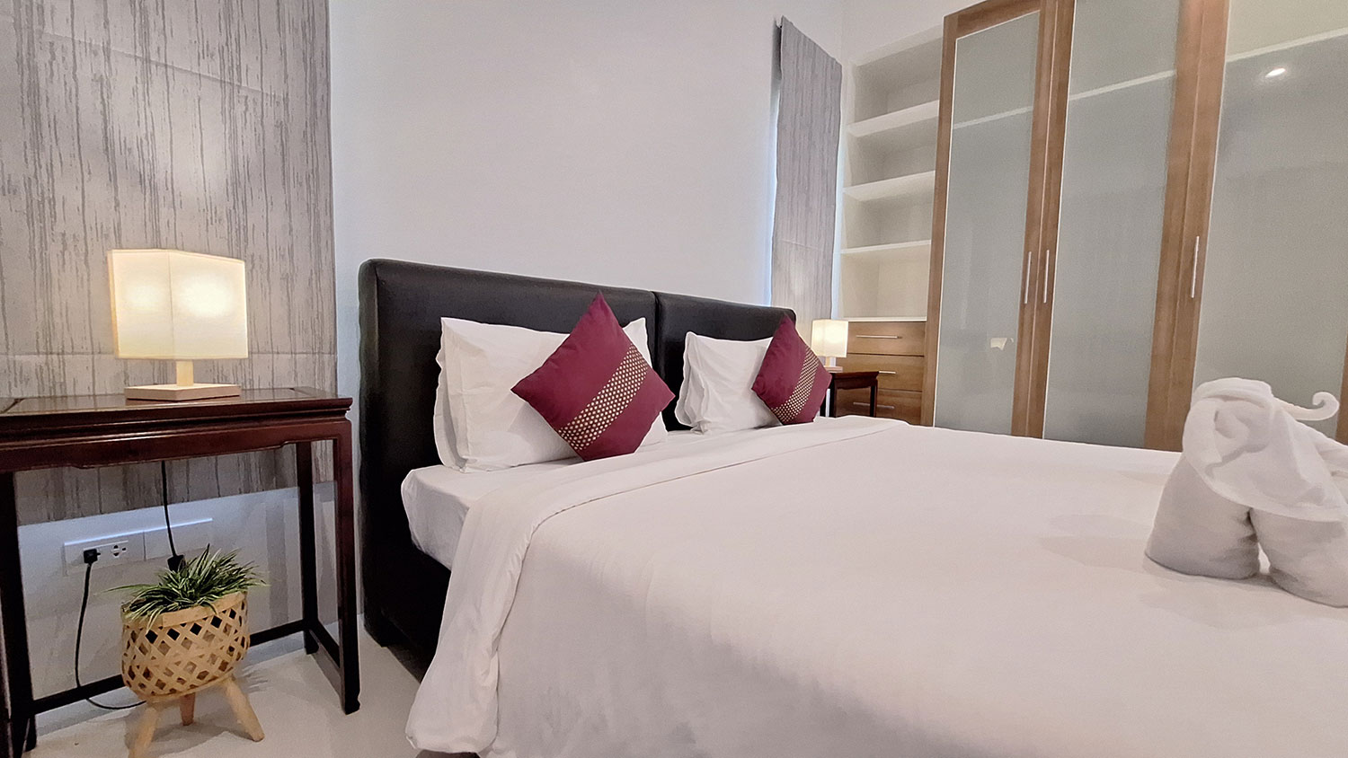 Official ThaiLife Residences project image showing modern bedroom white linens wood wardrobe for the Bang Muang, Takua Pa development. Confirm whether the image is completed-property photography, a show unit or a design visualisation before using it as construction-status evidence.
