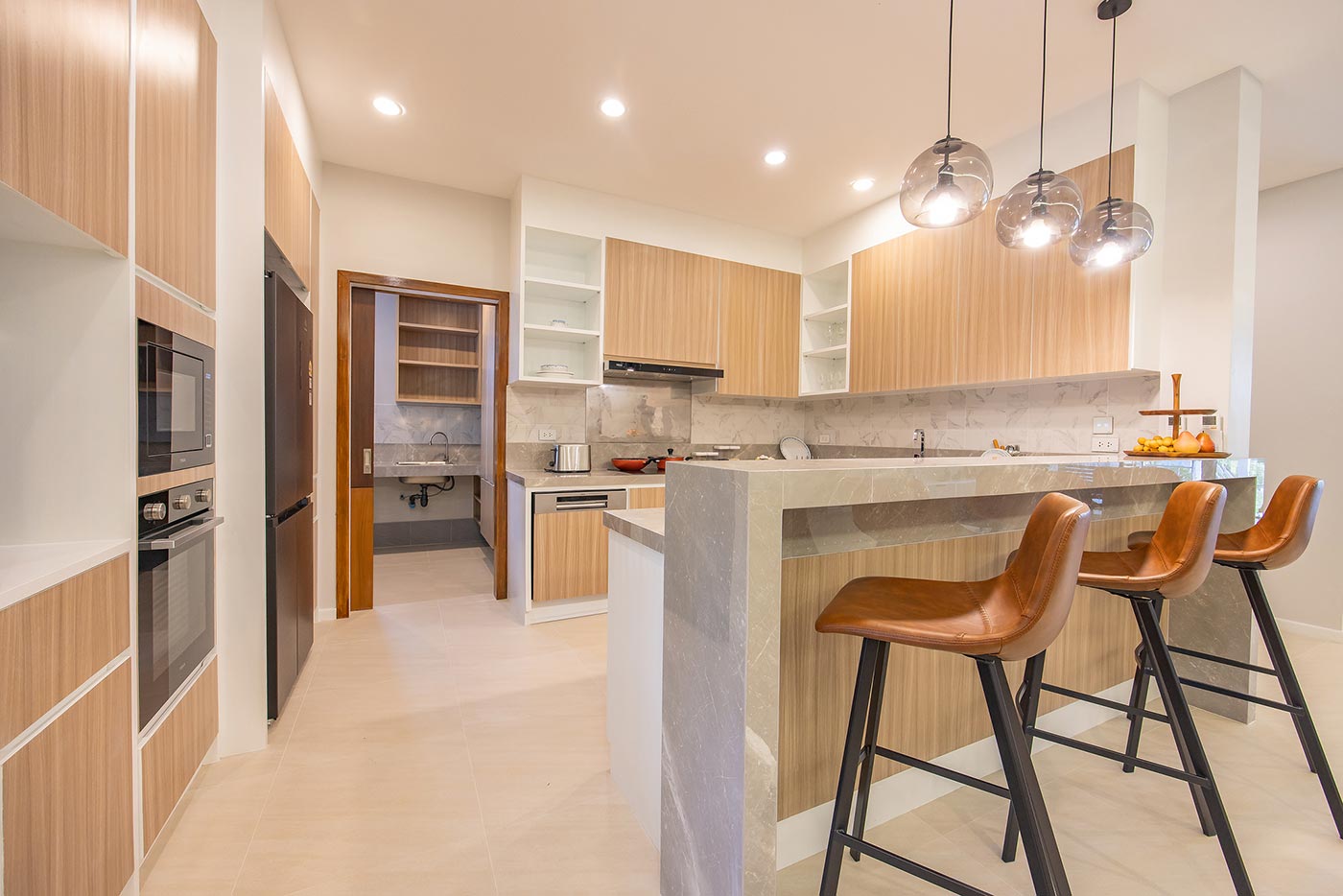 Official ThaiLife Residences project image showing modern kitchen with breakfast bar stools for the Bang Muang, Takua Pa development. Confirm whether the image is completed-property photography, a show unit or a design visualisation before using it as construction-status evidence.