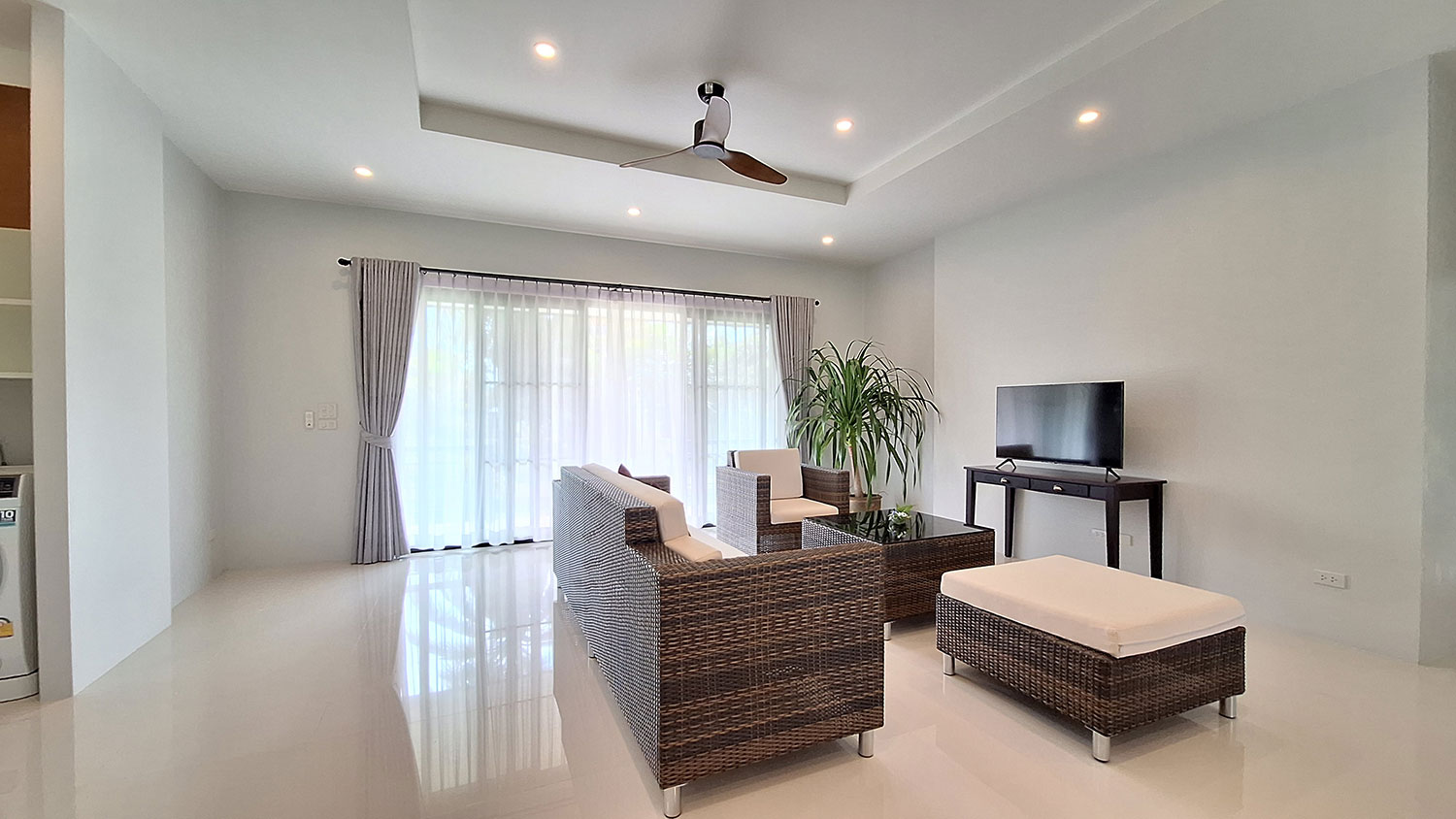 Official ThaiLife Residences project image showing modern living room with rattan furniture for the Bang Muang, Takua Pa development. Confirm whether the image is completed-property photography, a show unit or a design visualisation before using it as construction-status evidence.